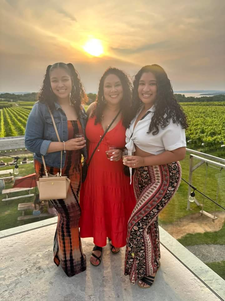 Three friends at a vineyard, sunset.